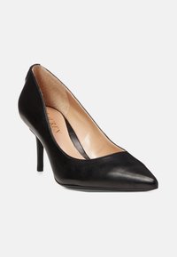 Tacco alto in pelle nera con punta affilata, texture liscia, sottile tacco a stiletto e un leggero abbassamento ai lati per un elegante profilo.