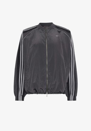 Chaqueta deportiva ligera negra con cremallera, tres rayas blancas en las mangas y pequeño logo de Adidas en el pecho.