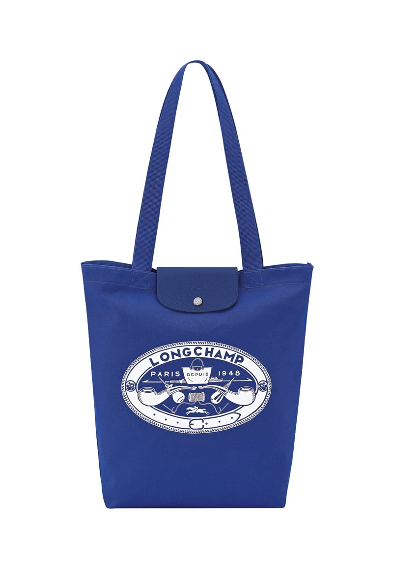 Blue tote bag made of durable fabric featuring a white logo design with "LONGCHAMP PARIS DEPUIS 1948" and an embossed button closure.