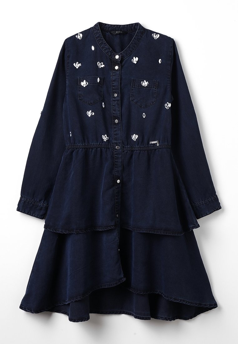 Tummansininen pitkähihaisessa kerrosmekossa on valkoista kukka-ompelua, etupainonappisuljenta, kaksi rintataskua ja kerrottu vyötärö.