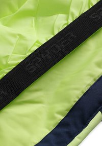 Helles grünes Jackenmaterial mit einer glatten Textur, versehen mit einem schwarzen elastischen Band, das mit "Spyder" beschriftet ist, entlang des Innenbereichs. Navyblaue Akzente sind sichtbar.
