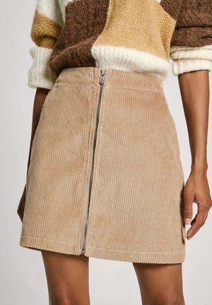Corduroy mini skirt in light beige with ribbed texture, featuring a front zipper closure and a straight hem.