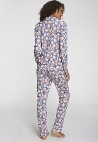 Blumen Schlafanzug-Set aus weichem Stoff mit blauem Hintergrund, hellpinkfarbenen Blumen, langen Ärmeln und geraden Hosen.
