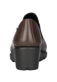 Scarpa in pelle marrone con punta arrotondata, tacco basso a blocco e suola in gomma nera. Presenta un dettaglio di cucitura e un accento metallico decorativo.
