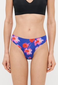 Virágos bikini alsó, kék háttérrel, piros és rózsaszín virágmintákkal, rugalmas anyagból készült, közepes derékbőséggel.