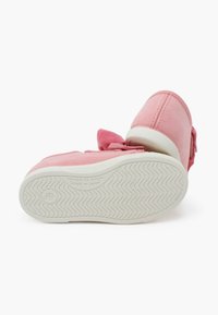 Scarpe in suede rosa con suola in gomma e dettagli bianchi. Presentano un fiocco decorativo sulla parte superiore e dettagli texture sulla suola.
