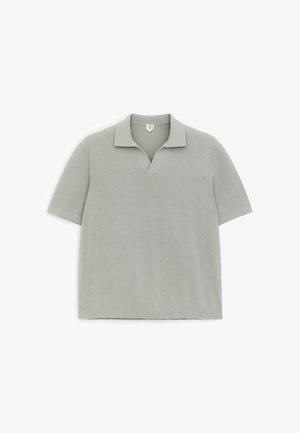 Helehall lühikeste varrukatega kootud polo särk V-kujulise kaelusega, laotatud valgele taustale.