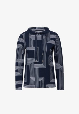 Námořnický modrý mikina s bílým geometrickým vzorem. Má vysoký límec, šňůrku a dlouhé rukávy vyrobené z texturované látky.