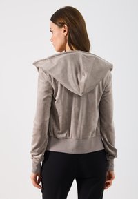 Γκρι φούτερ από ψεύτικη σουέντ με μεγάλο καπάκι, ριμπ μανσέτες και cropped σχεδιασμό, που παρουσιάζει λεία υφή και μινιμαλιστικό στυλ.