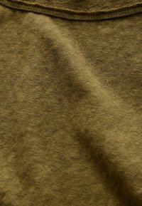 Olivgrön bomullstyg med en mjuk, texturerad yta och subtila färgvariationer, med en ribbad halsringning.