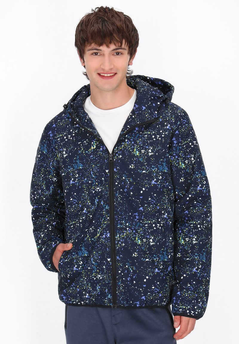 Navyblauwe hooded jack met een spetterpatroon in groen en wit, voorzien van een volledige rits en zijzakken, gemaakt van een glad, lichtgewicht materiaal.