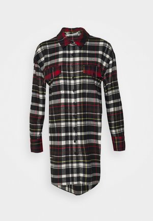 Blousejurk met lange mouwen in een geruit patroon van zwart, wit, rood en geel, met knopen aan de voorkant, twee borstzakken en een puntige kraag.