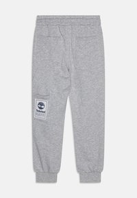 Šedé tepláky majú elastický pás, rebrované manžety a dve zadné vrecká. Pozoruhodná je bočná nášivka s logom Timberland.