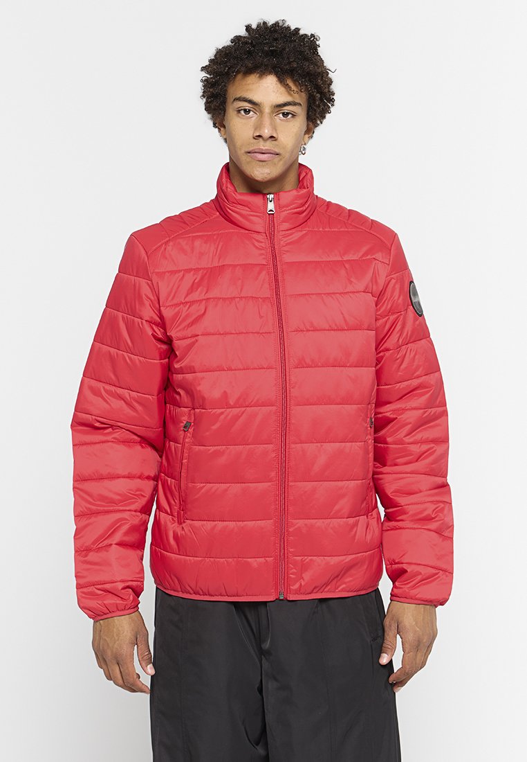 Chaqueta de plumas roja con alto cuello, cierre de cremallera en la parte frontal y costuras horizontales. Dos bolsillos laterales y un logo circular en el hombro izquierdo.