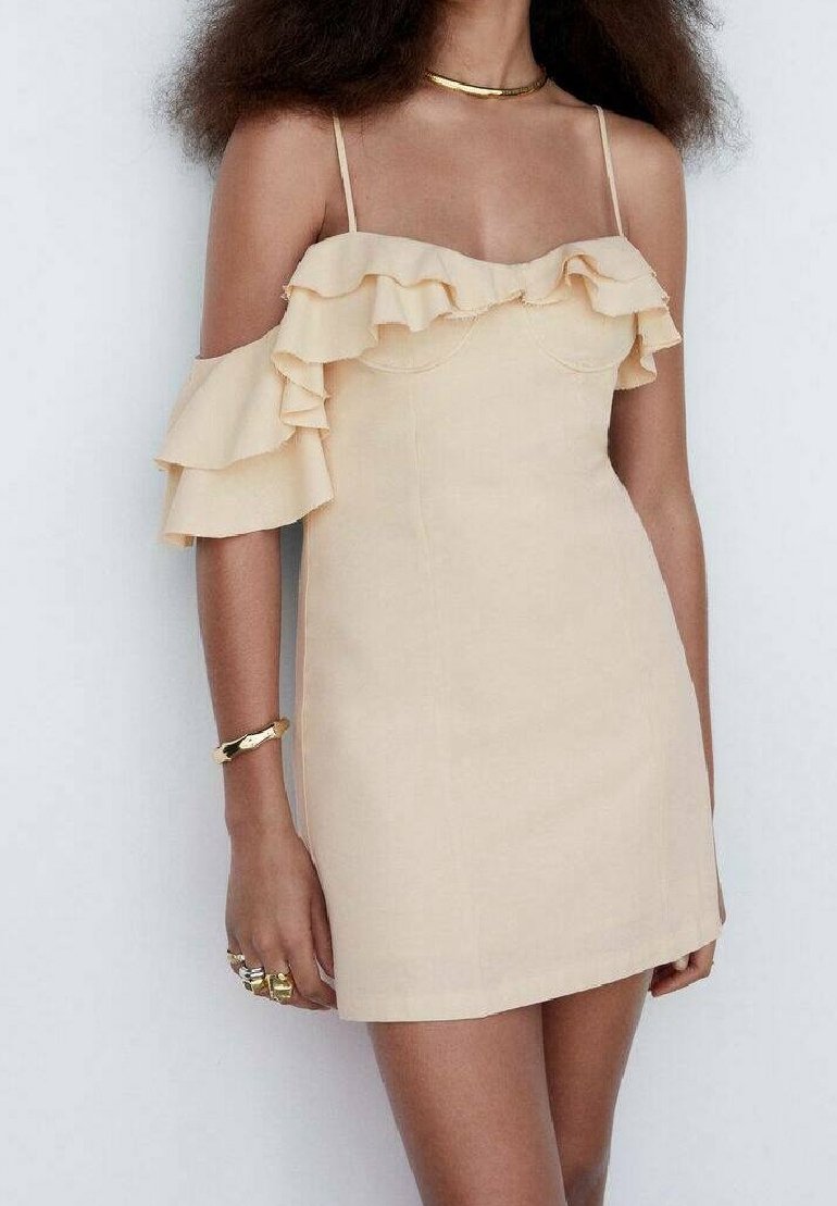 Beige schulterfreies Kleid mit Rüschendetails, tailliertem Schnitt und geradem Saum. Verfügt über dünne Träger und eine glatte Stofftextur.