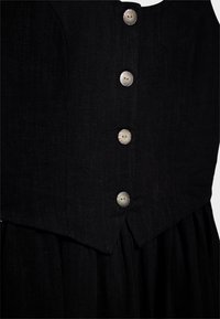 Robe noire avec un corsage ajusté à encolure en V et cinq boutons contrastants, jupe fluide et tissu texturé.