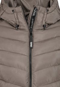 Leichte braune gepolsterte Jacke mit durchgehendem Reißverschluss, verstellbarem Kapuze und schwarzen Logodetails. Verfügt über horizontale Steppoberfläche.