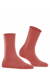 Korallenfarbene Knöchelsocken aus glattem, dehnbarem Material mit einem eng gestrickten Design, das eine gleichmäßige Textur und eine nahtlose Zehenpartie aufweist.