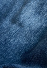 Denimtyg i mörkblått med en lätt textur, med en blandning av ljusare och mörkare trådar i en twillväv.