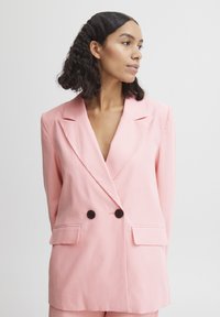 Lyserød double-breasted blazer med klappede lommer, skrå lapeller og mørke knapper. Glat stof og tætsiddende pasform.