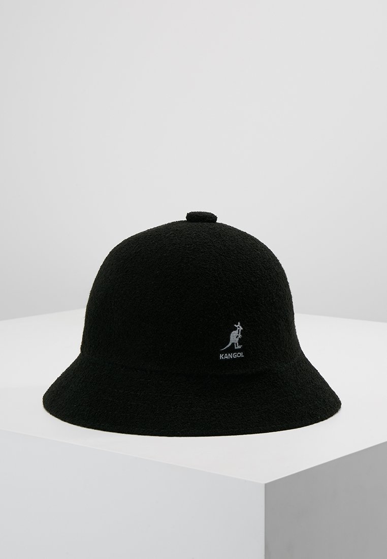 Cappello a secchiello nero realizzato in tessuto testurizzato, con corona arrotondata, visiera ampia e un piccolo logo Kangol sulla parte anteriore.