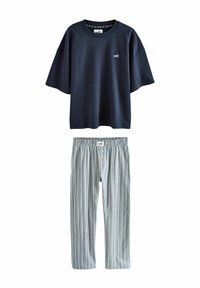 Marineblaue Kurzarm-T-Shirt mit "self."-Logo kombiniert mit hellblauen und weißen gestreiften elastischen Hosen mit Knopfleiste.