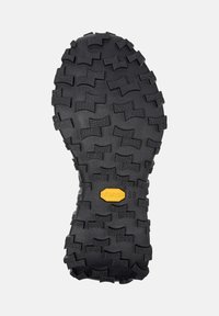 Mustaa kumista valmistettu kengänpohja syvällä urakuviolla, jossa on keltainen Vibram-logo. Suunniteltu pitoon ja kestävyteen.
