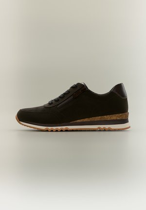 Sort lav-til-jord sneaker med snørelukning foran, sidelås, korktekstureret mellemsål og rillede gummiydersål på neutral baggrund.