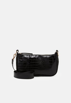 Petit sac d'épaule noir à texture crocodile, avec ferrures dorées et une longue bandoulière amovible sur fond uni.