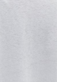 Tessuto di cotone grigio chiaro con una texture morbida e un sottile motivo melangiato, che presenta una superficie liscia e leggermente irregolare.
