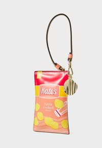Brieftasche in Form eines Beutels für kettle-cooked Kartoffelchips in Pink und Gelb, ausgestattet mit einem Lederarmband und einem goldenen, muschelförmigen Reißverschlussanhänger.