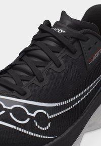 Μαύρο αθλητικό παπούτσι με επάνω μέρος από διχτυωτό υλικό, μαύρα κορδόνια, λευκές και γκρι λεπτομέρειες, και το λογότυπο "Endorphin" στην πλευρά κοντά στη φτέρνα.