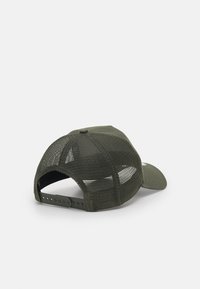 Casquette en mesh vert avec un panneau avant solide et une visière incurvée, dotée d'une sangle en plastique réglable et de trous de ventilation à l'arrière.