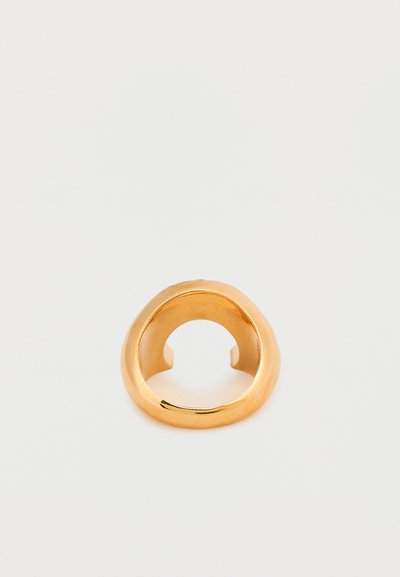 Χρυσό δαχτυλίδι με λείο, στρογγυλεμένο σχέδιο, που διαθέτει μια ελαφρώς ανοιχτή ταινία. Η επιφάνεια έχει γυαλιστερό φινίρισμα και διακριτική λάμψη.