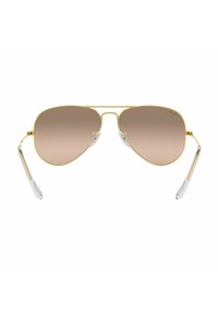 Occhiali da sole aviator in metallo dorato con lenti a degradé marroni, punte delle aste in plastica trasparente e montature sottili. Design classico con una finitura elegante.