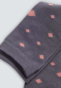 Calcetines grises con pequeños patrones de diamantes rosas, hechos de un material suave y texturizado, con un diseño de puño doblado.