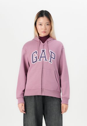 Zip-up hettegenser i lavendel med "GAP" logo i hvit og marineblå. Har en frontglidelås, to lommer og hette med snøring.