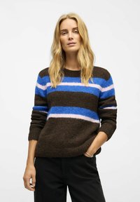 Brown striped sweater with blue, pink, and white horizontal lines. Soft texture, crew neckline, and relaxed fit. Paired with black pants.