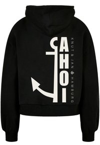 Schwarzer Hoodie mit einer frontalen Kängurutasche, der große weiße Blockschrift und ein Anker-Graphic auf der Rückseite aufweist. Weicher Stoff, lässige Passform.