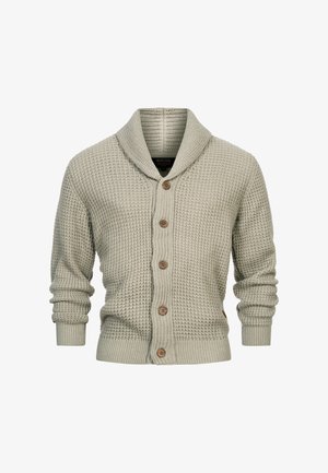 Világoszöld kötött kardigán, sálgallérral, fából készült gombokkal záródik, és bordázott mandzsettákkal rendelkezik. Anyaga szövetes és vastag.