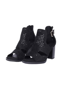 Sandali con tacco in suede nero caratterizzati da design a intaglio, punte scoperte e una cinghia sul retro con fibbia regolabile. Tacco alto a blocco.