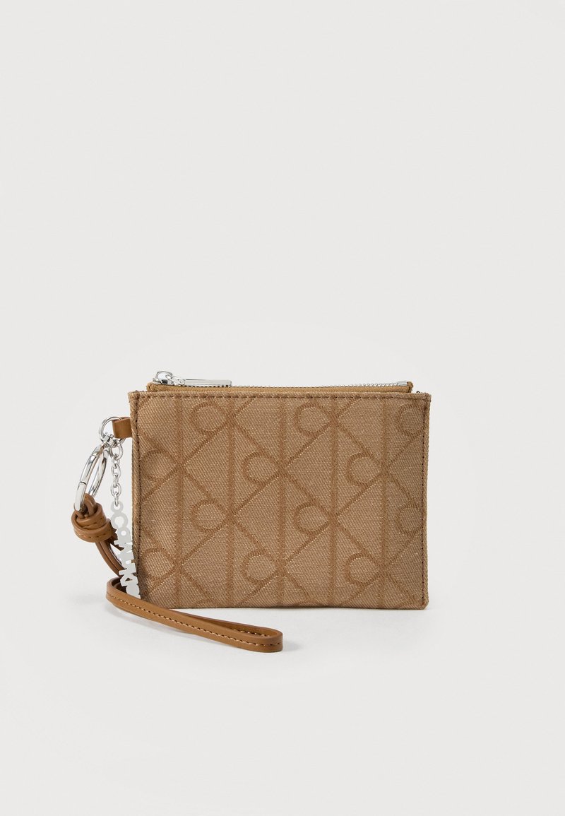 Μικρό ταμπά υφασμάτινο βραχιόλι με γεωμετρικό ανάγλυφο σχέδιο, ασημί φερμουάρ και δερμάτινο λουρί με μεταλλικό μπρελόκ και κρεμαστό διακοσμητικό.