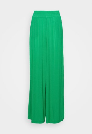 Pantalons larges verts en tissu lisse et léger, dotés d'une taille élastique et d'une silhouette ample et fluide.