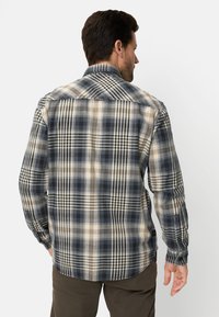 Geruit overhemd met lange mouwen in tinten marineblauw, crème en lichtbruin. Voorzien van een kraag, knoopmanchetten en een afgeronde zoom. Zachte stoftextuur.