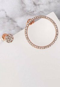 Roséguldörhängen med en cirkulär hoop prydd med en rad klara rhinstenar och en mindre rund stud med en liknande rhinstendesign.