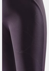 Lila Sportleggings mit glatter Textur, hohem Stretchanteil und einem subtilen, dunkleren Marmor-Muster für visuelles Interesse.