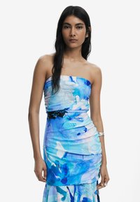 Robe sans bretelles dans un motif aquarelle bleu, dotée de fronces, d'un bustier ajusté et d'un ourlet évasé. Tissu doux avec un éclat subtil.