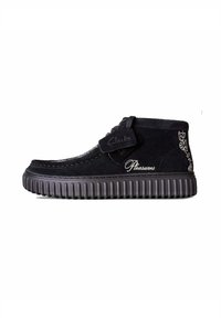Schwarze Wildleder-Stiefeletten mit einer gerippten Gummisohle. Mit gesteppten Details und aufgestickten "Clarks"- und "Pleasures"-Logos.