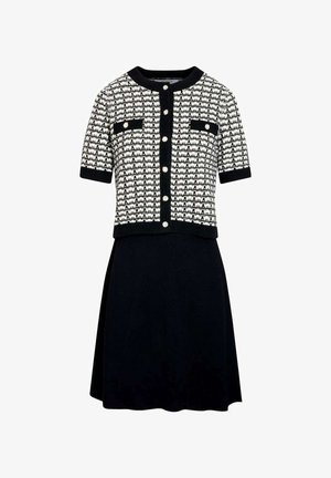 Zwart-witte korte mouwen gebreide cardigan met knopen aan de voorkant en opgestikte zakken, gecombineerd met een effen zwarte A-lijn rok.