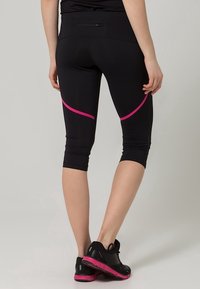 Black athletic capris with a fitted design, featuring pink accent lines and a back pocket. Made from stretchy, lightweight fabric.